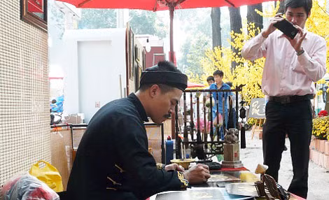 Hình ảnh các ông đồ bên phố ngày giáp tết đã quen thuộc với người dân TP HCM nhiều năm gần đây.