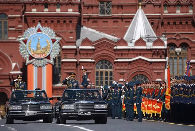 Bộ trưởng Quốc phòng Nga Sergei Shoigu (đứng bên trái trên xe đi trước) duyệt đội ngũ trước lễ duyệt binh.