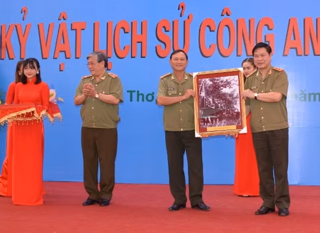 Đại tá Võ Ngọc Hữu, Phó Giám đốc Công an tỉnh Đồng Tháp trao bức ảnh đơn vị Quốc gia tự vệ cuộc Sa Đéc diễn binh năm 1948, cho lãnh đạo Tổng cục Chính trị CAND.