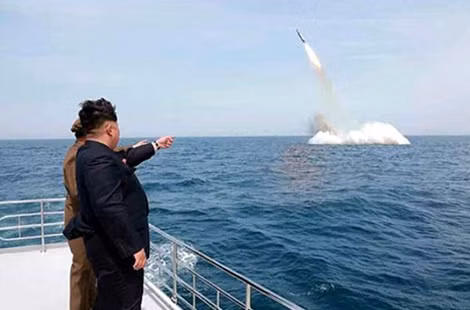 Lãnh đạo Triều Tiên Kim Jong Un chỉ tay về phía một tên lửa đạn đạo được phóng từ dưới nước tại bờ biển phía đông bắc nước này (ảnh: DailyMail).