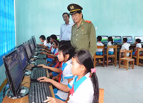 Trung tướng Châu Văn Mẫn bên các em học sinh Trường Tiểu học Trần Phú vừa được tặng máy vi tính.