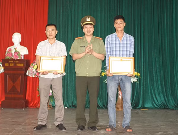 Thiếu tá Phan Tuấn Anh, Trưởng Phòng xây dựng phong trào toàn dân bảo vệ ANTQ Công an Nghệ An thừa uỷ quyền trao giấy khen cho 2 quần chúng có thành tích xuất sắc trong phòng trào toàn dân bảo vệ ANTQ.