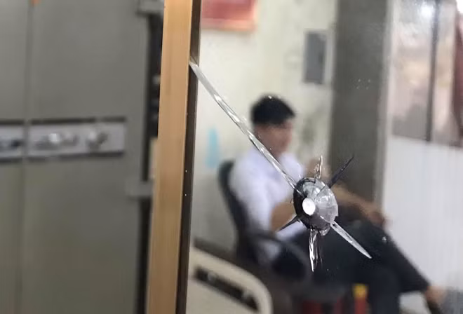 Viên đạn bị hung thủ bắn ra vẫn còn găm trên mặt kính tại hiện trường