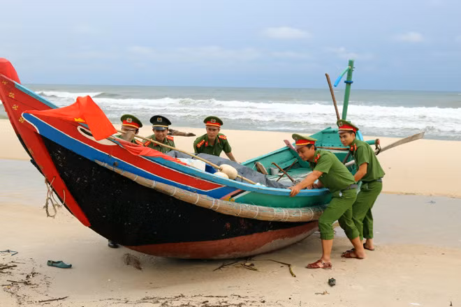 Công an Quảng Bình về các xã ven biển giúp ngư dân đưa tàu, thuyền lên bờ đề phòng sóng đánh vỡ thuyền.