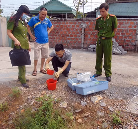 Tổ công tác lấy mẫu nước xả thải không qua xử lý để giám định.