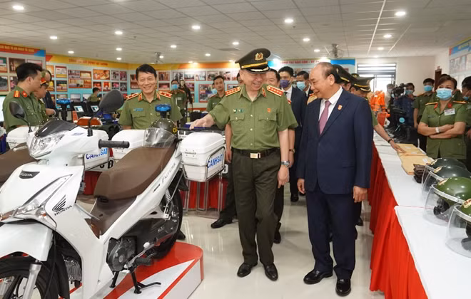 Thủ tướng Nguyễn Xuân Phúc và Bộ trưởng Tô Lâm thăm khu trưng bày thiết bị an ninh. (Ảnh: VGP).