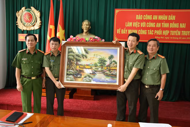 Đại tá Phạm Quang Khải, Tổng Biên tập Báo CAND trao bức tranh lưu niệm tặng Công an tỉnh Đồng Nai.