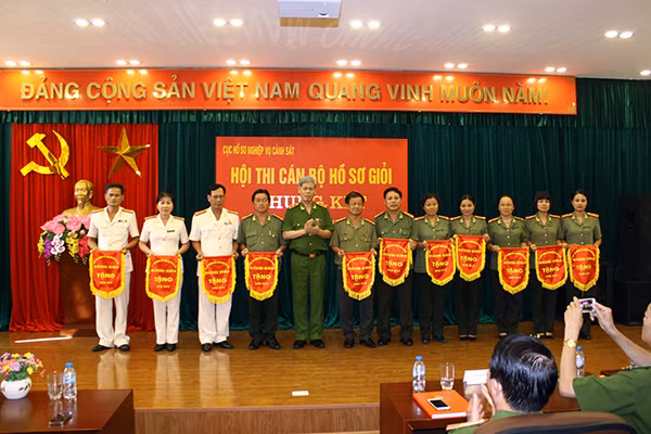 Trung tướng Đỗ Đình Nghị, Phó Tổng cục trưởng Tổng cục Cảnh sát trao Cờ lưu niệm cho các đơn vị tham gia Hội thi.