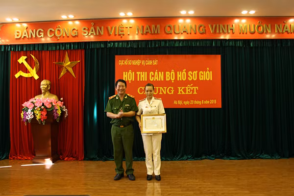 Thiếu tướng Nguyễn Huy Mạ, Cục trưởng Cục Hồ sơ nghiệp vụ Cảnh sát, Trưởng Ban tổ chức Hội thi trao giải Nhất cho thí sinh Nguyễn Thị Hằng, Phòng Hồ sơ Công an tỉnh Thanh Hóa.