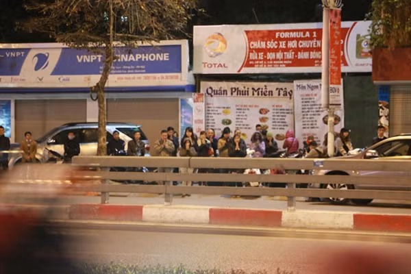 Nhiều người đến muộn không còn chỗ phải đứng bên đường, ngồi giữa dải phân cách bái vọng với mong ước cầu tài, cầu lộc và cầu bình an trong năm mới.