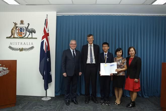 Em Nguyễn Mạnh Quân giành huy chương cho lứa tuổi thiếu niên tại cuộc thi AMC, cùng Đại sứ Australia Craig Chittick và ông Mike Clapper, Giám đốc điều hành Hội đồng Toán học Australia