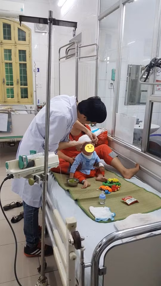 Bs. Nguyễn Mạnh Hùng khám cho bé .