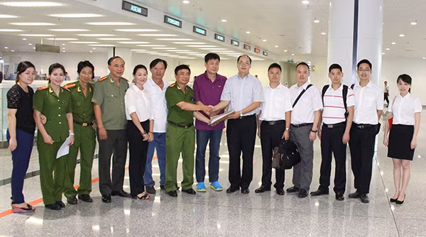 Đại diện Cục Cảnh sát truy nã tội phạm bàn giao hồ sơ, đối tượng truy nã Yin Wen Sheng (đứng giữa mặc áo phông tím) cho cơ quan chức năng Trung Quốc tại sân bay quốc tế Nội Bài.