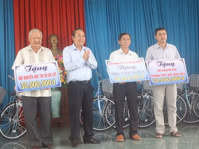 Phó Thủ tướng Thường trực Chính phủ Trương Hòa Bình trao quà cho một số Hội Khuyến học tại Cai Lậy.