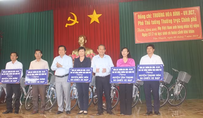 Phó Thủ tướng Thường trực Trương Hòa Bình cùng ông Phạm Văn Rạnh, Ủy viên Trung ương Đảng, Bí thư Tỉnh ủy - Chủ tịch HĐND tỉnh Long An trao xe đạp cho đại diện các huyện của Long An.