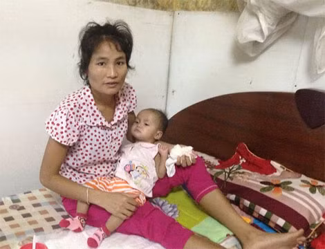 Trên tay chị Xúm, con bé nằm bất động, đôi mắt đen tròn nhìn trân trân vào một điểm mơ hồ nào đó.
