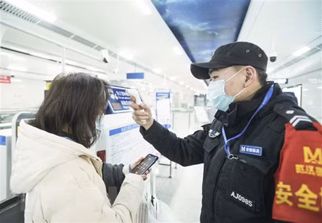 Kiểm tra thân nhiệt một hành khách nhằm ngăn chặn sự lây lan của dịch viêm đường hô hấp cấp do virus 2019-nCoV tại nhà ga đường sắt Vũ Hán, tỉnh Hồ Bắc, Trung Quốc. Ảnh: THX Kiểm tra thân nhiệt một hành khách nhằm ngăn chặn sự lây lan của dịch viêm đường hô hấp cấp do virus 2019-nCoV tại nhà ga đường sắt Vũ Hán, tỉnh Hồ Bắc, Trung Quốc. Ảnh: THX