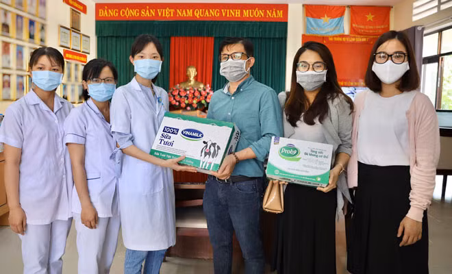 Nhân viên của bệnh viện Bạch Mai đang tiếp nhận các sản phẩm của Vinamilk như sữa chua uống Probi, sữa tươi 100%,…