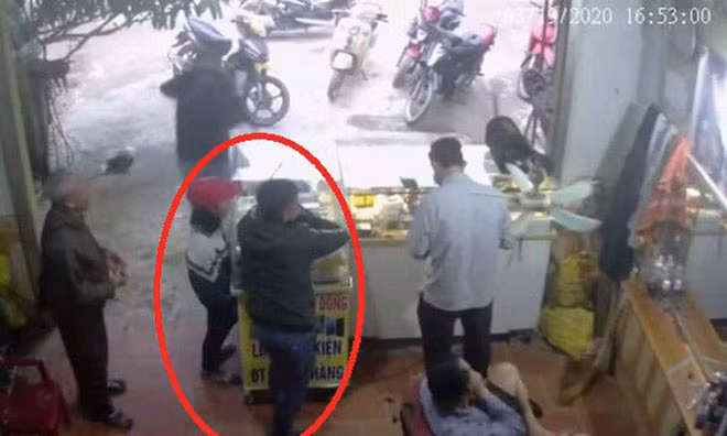 Khoát cùng em T vào cửa hàng bán điện thoại (ảnh cắt từ camera). Khoát cùng em T vào cửa hàng bán điện thoại (ảnh cắt từ camera).