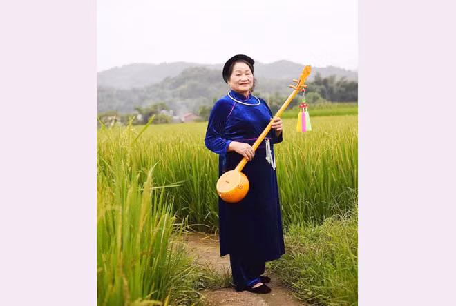 Nghệ nhân Ưu tú Nguyễn Thị Bông say sưa bên cây đàn tính.
