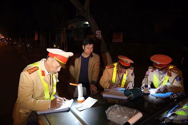 Lực lượng CSGT lập biên bản xử lý phương tiện chở quá số người quy định.
