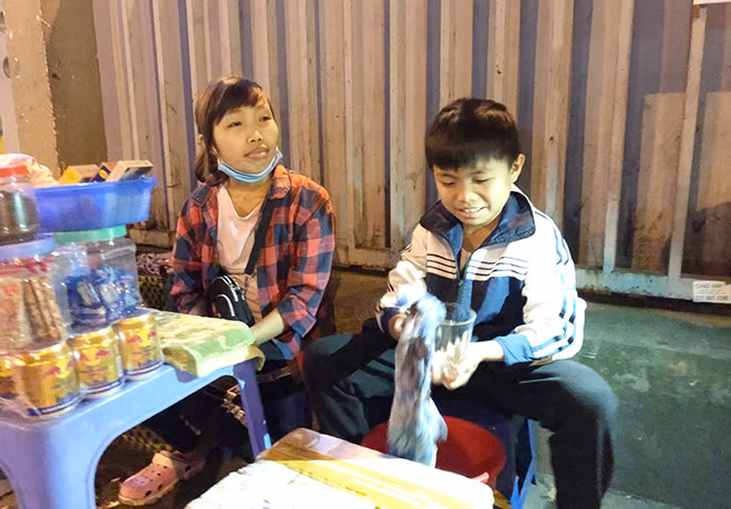 Để có tiền đi viện, Trần Thị Như và em trai tranh thủ bán trà đá gần cổng viện vào buổi tối.