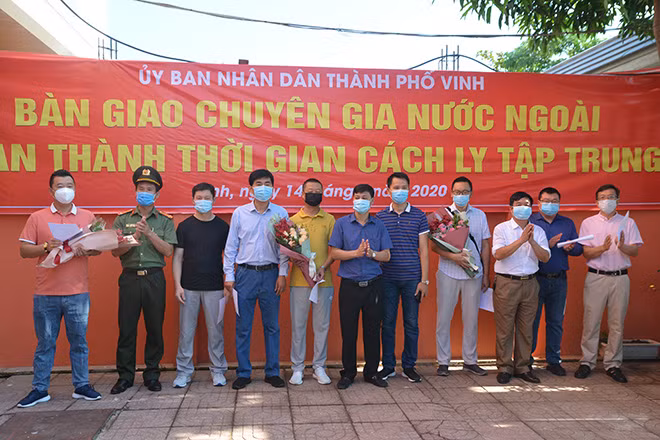 Giám đốc Trung tâm Y tế thành phố trao Giấy xác nhận hoàn thành cách ly cho các chuyên gia.