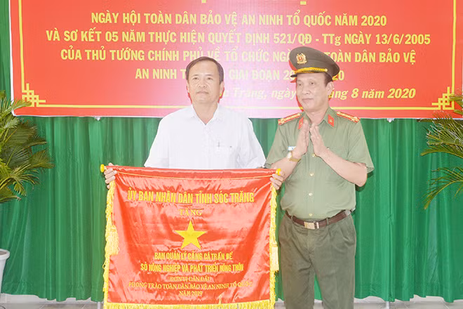 Đại tá Phạm Quốc Việt, Phó Giám đốc Công an tỉnh Sóc Trăng, trao Cờ thi đua xuất sắc của UBND tỉnh tặng Ban quản lý cảng cá Trần Đề.