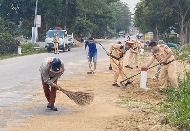 Các chiến sỹ CSGT cùng người dân dọn dẹp cát sỏi rơi vãi trên đường