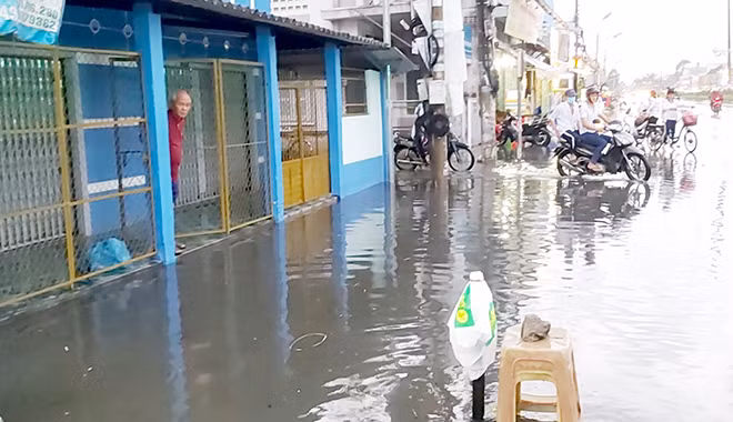 Tạnh mưa đã lâu nhưng nước vẫn tràn ngập trước nhà các hộ dân và trên QL1A ở đoạn thị trấn Tân Hiệp và xã Tân Lý Tây, huyện Châu Thành, tỉnh Tiền Giang.