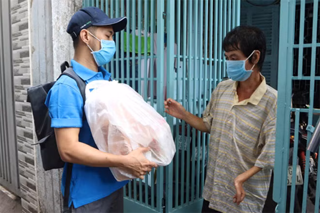 Nhân viên Novaland tặng quà cho một hoàn cảnh bị tật ở tay hiện mưu sinh bằng nghề bán vé số ở phường 13, quận 10.