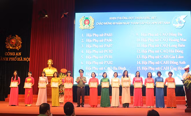 Thiếu tướng Đoàn Ngọc Hùng tặng giấy khen của Giám đốc CATP cho các tập thể có thành tích trong đợt thi đua đặc biệt chào mừng 90 năm ngày thành lập Hội LHPN Việt Nam.