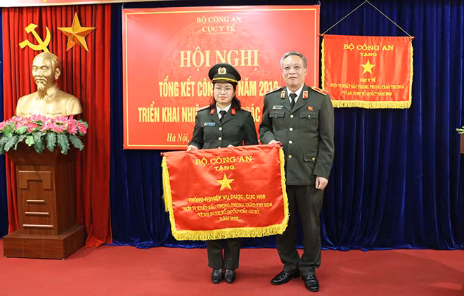 Đồng chí Thiếu tướng Nguyễn Khắc Thủy trao Cờ Thi đua của Bộ Công an cho Phòng nghiệp vụ Dược.