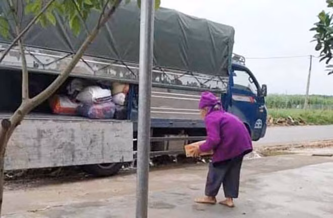 Cụ Cháu còng lưng bê thùng mì tôm ra xe cứu trợ. Cụ Cháu còng lưng bê thùng mì tôm ra xe cứu trợ.