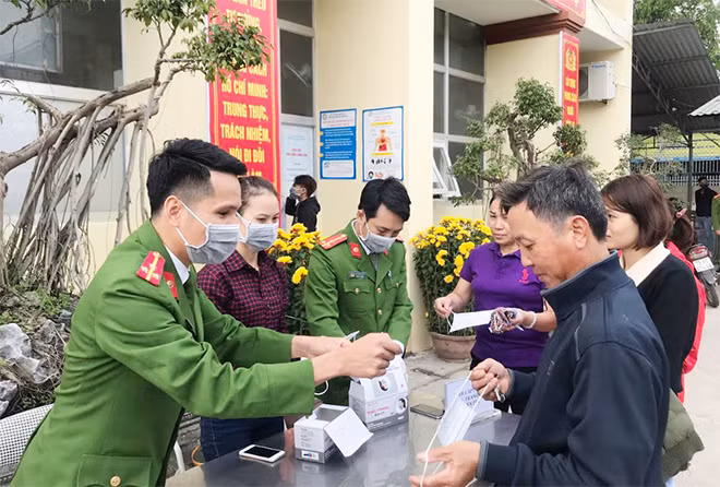 Cán bộ, chiến sỹ Phòng Cảnh sát quản lý hành chính về trật tự xã hội phát khẩu trang miễn phí cho người dân.