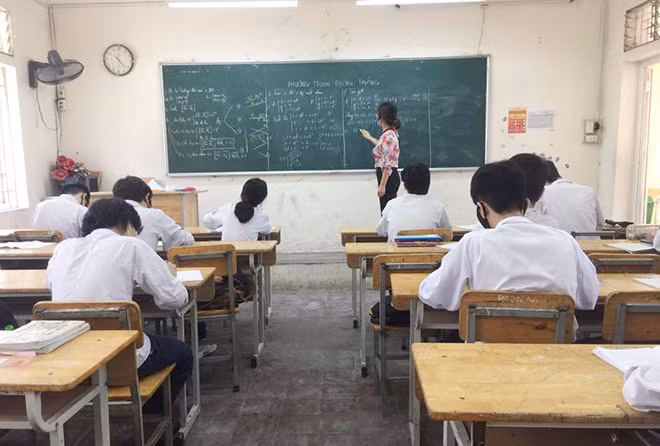 Học sinh Trường THPT Trương Định đeo khẩu trang, mỗi em ngồi 1 bàn đảm bảo giản cách theo quy định trong buổi học đầu tiên.