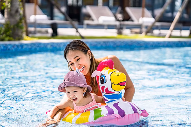 Du khách vui đùa dưới làn nước trong xanh tại bể bơi của Mövenpick Resort Waverly Phú Quốc
