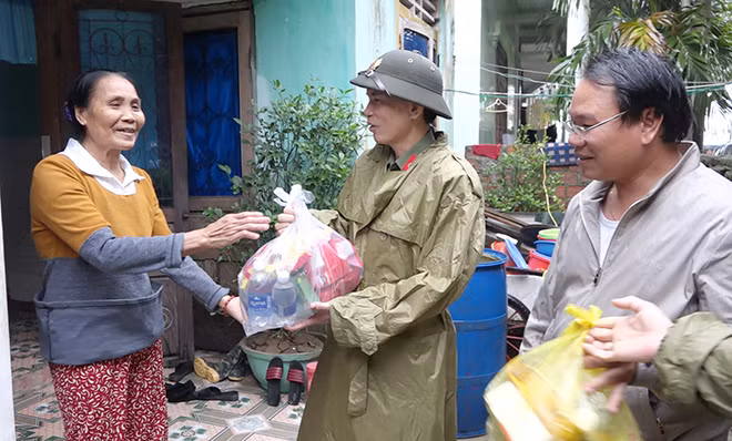 Đại tá Phan Đăng Tĩnh, Phó Giám đốc, trao lương thực cứu trợ cho người dân vùng lũ xã Quảng Văn, TX. Ba Đồn.