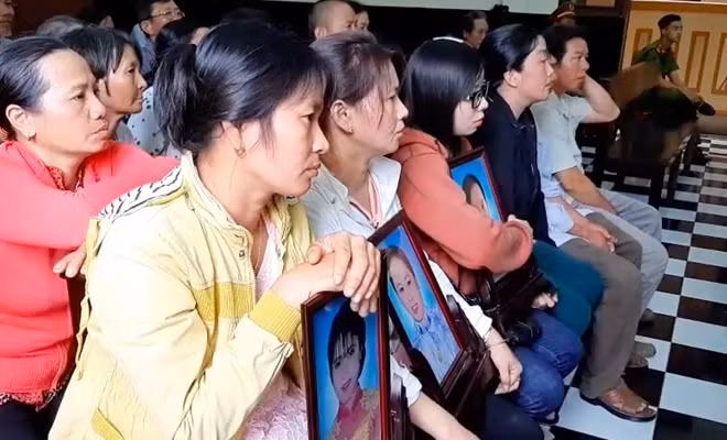 Người thân mang di ảnh 3 nạn nhân đến toà.