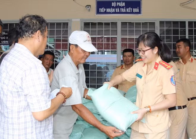 Cán bộ chiến sĩ tặng gạo cho người dân.