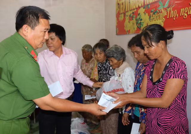 Lãnh đạo Công an huyện Cầu Ngang trao quà tết cho người người nghèo.