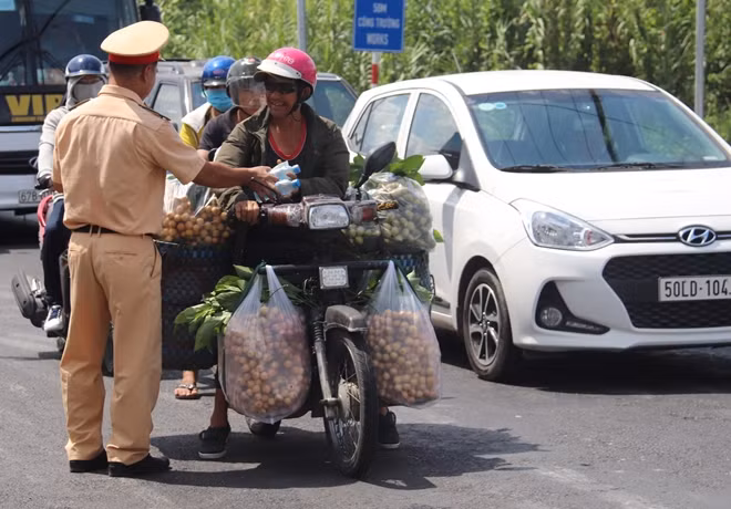 Công an quận Ô Môn phát nước suối, khăn lạnh cho người dân.