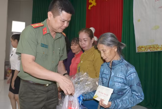 Thiếu tá Nguyễn Văn Bình, Phó trưởng CQĐD Báo CAND tại TP Hồ Chí Minh trao quà Tết cho người dân Châu Thành.