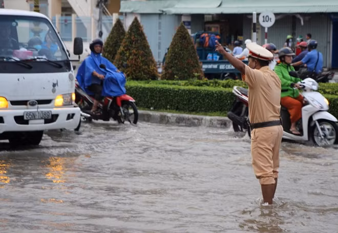 Cán bộ CSGT điều tiết phương tiện, trong điều kiện triều cường dâng cao.