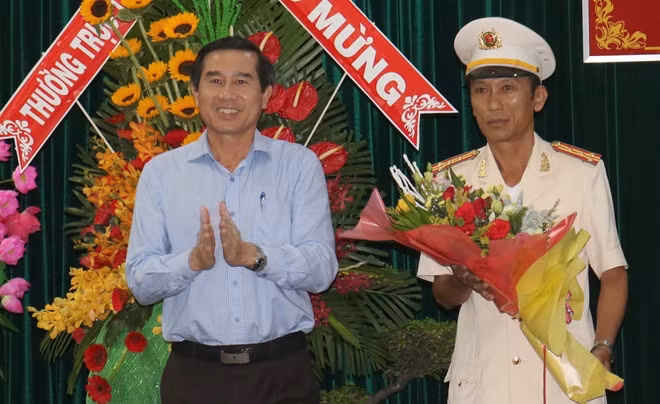 Đồng chí Lê Văn Hưởng, Phó Bí thư Tỉnh uỷ - Chủ tịch UBND tỉnh Tiền Giang tặng hoa chúc mừng tân Giám đốc Công an tỉnh Tiền Giang.