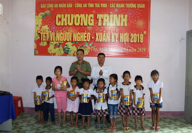Đại diện Công an Trà Vinh và Công ty NutiFood tặng sữa cho học sinh.