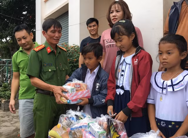 Trung tá Nguyễn Văn Một, Trưởng Công an phường 9 tặng quà cho các em học sinh.