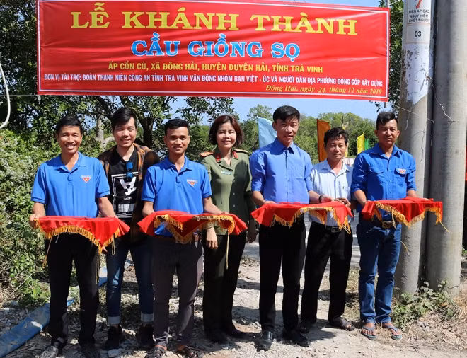 Các đại biểu tham gia cắt băng khánh thành cầu nông thôn.