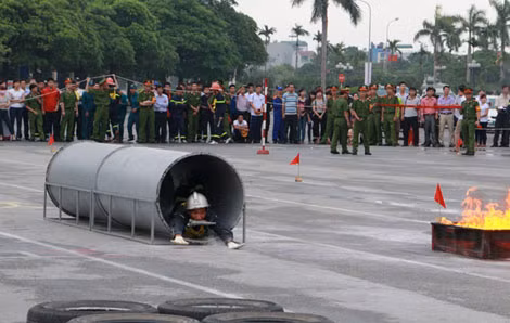 Các vận động viên thực hiện bài thi chạy tiếp sức 4 x100m cứu người và chữa cháy: Lao mình qua ống cống tới nơi lửa cháy. Các vận động viên thực hiện bài thi chạy tiếp sức 4 x100m cứu người và chữa cháy: Lao mình qua ống cống tới nơi lửa cháy.