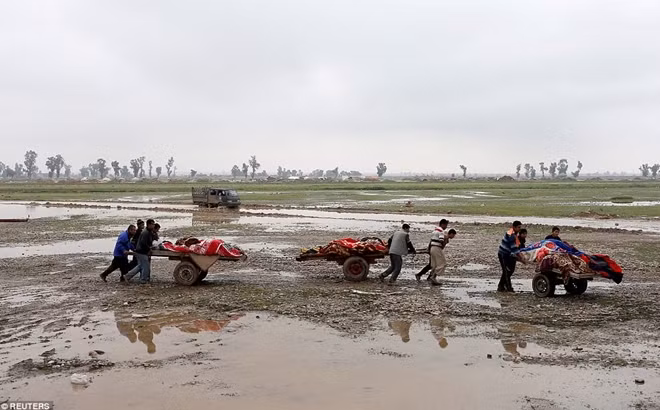 Những người thân đang di chuyển thi thể của các nạn nhân thiệt mạng trong cuộc không kích giữa Iraq và IS tại Mosul ngày 17-3.